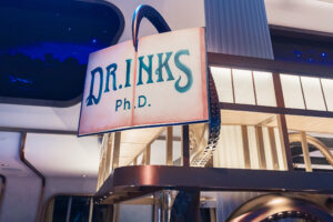 Close-up of the DR INK Ph.D. sign held up by an octopus tentacle with ambient lighting.